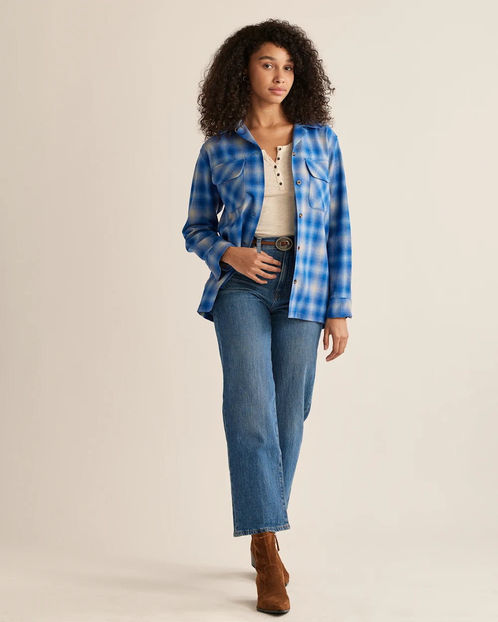 A woman wearing a Pendleton Women's Navy Mix Ombre plaid shirt with a mandarin collar, paired with blue jeans. She is posing against a plain background.