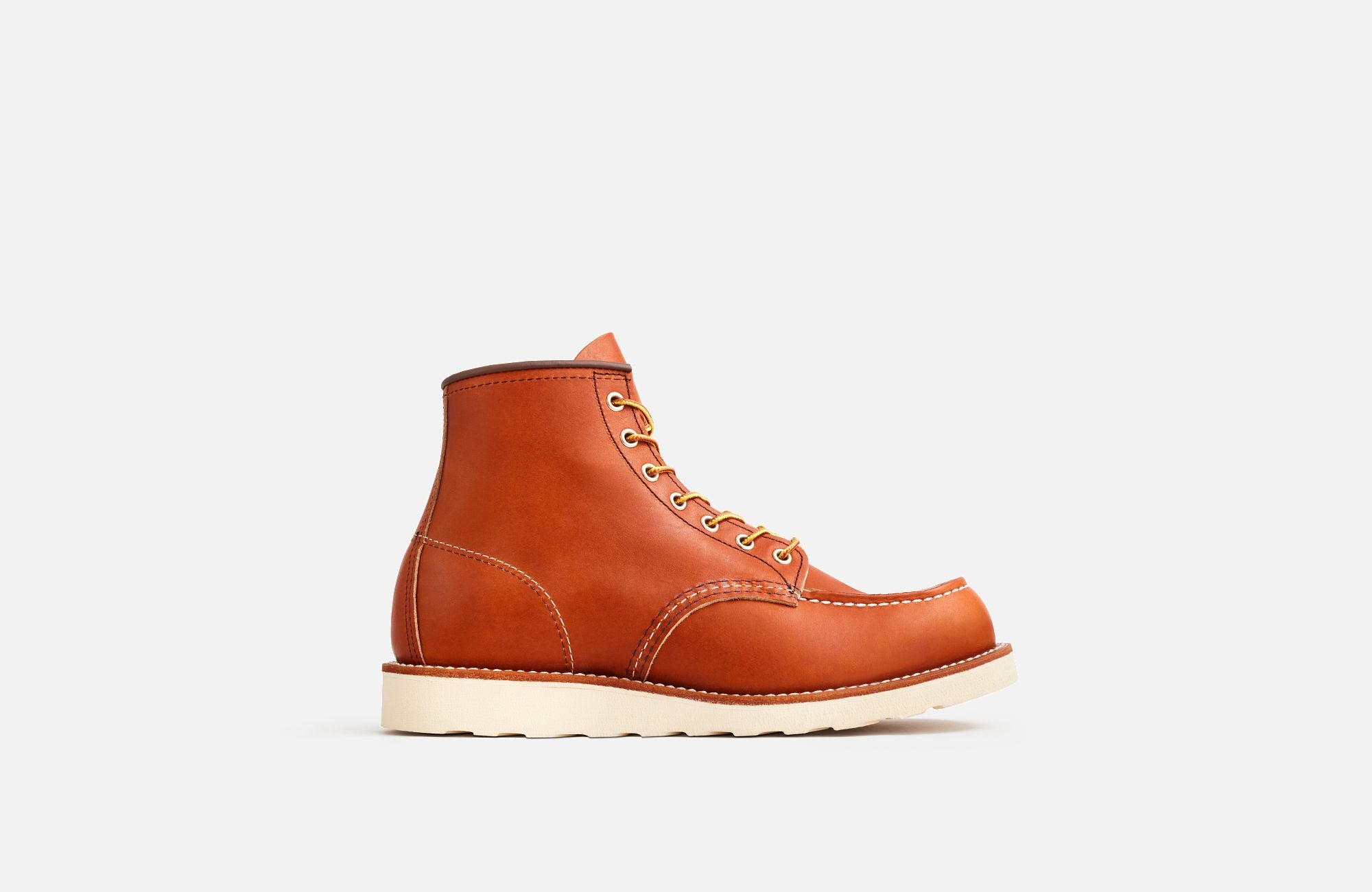 Side View of A Red Wing men's moc toe boot made of brown premium leather, featuring a Goodyear welt construction and a Traction Tred rubber outsole.