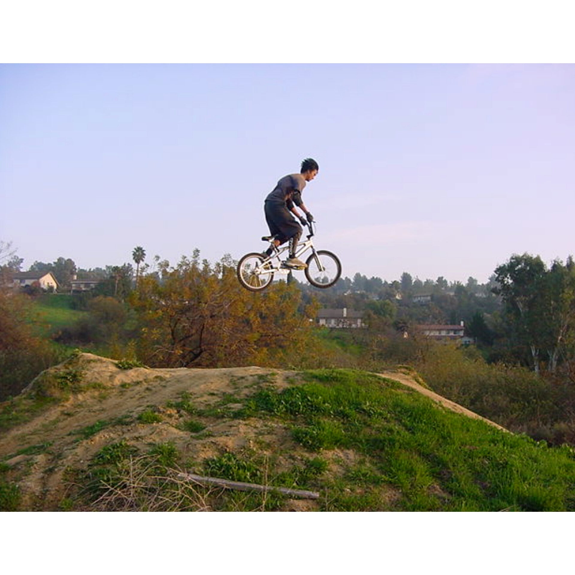 A Photo of young Steven Dang on his BMX bike in mid air over a hill