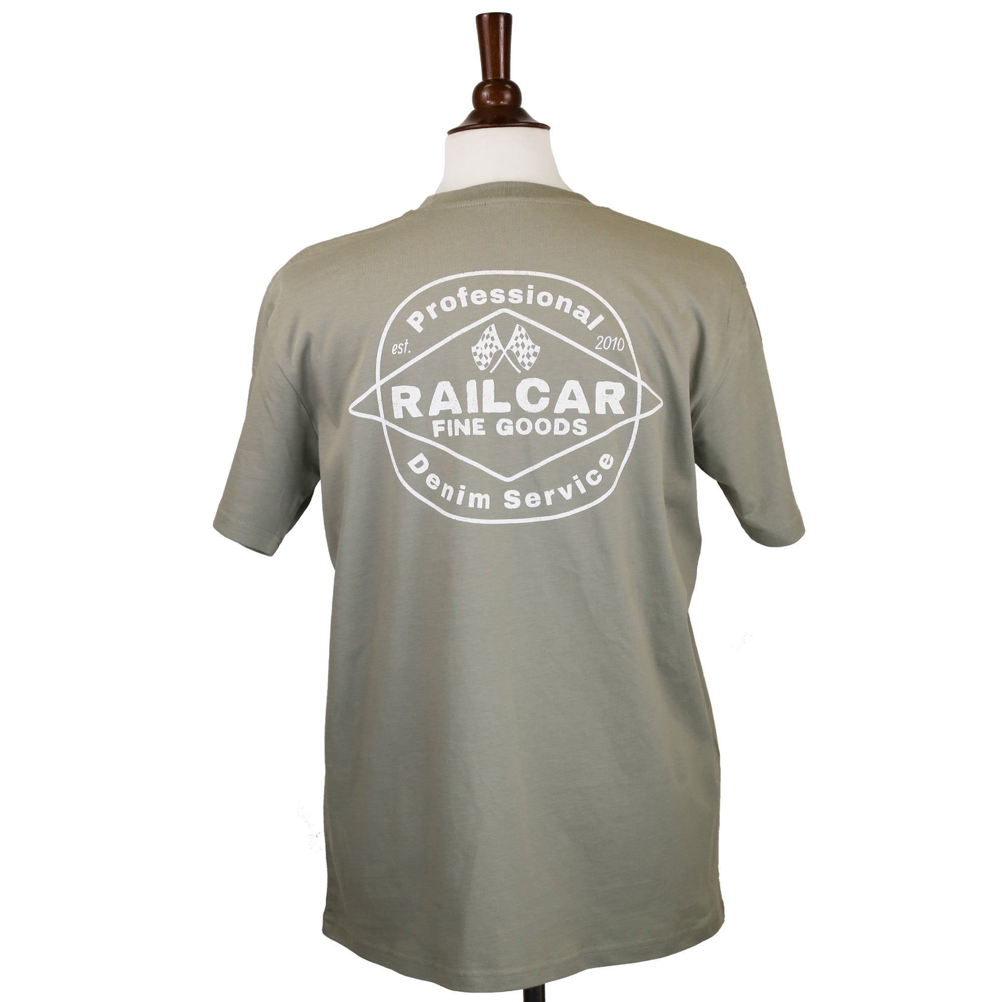 A sage green tee shirt with 'Professional Denim Service' and 'Railcar Fine Goods' printed in off white on the back.