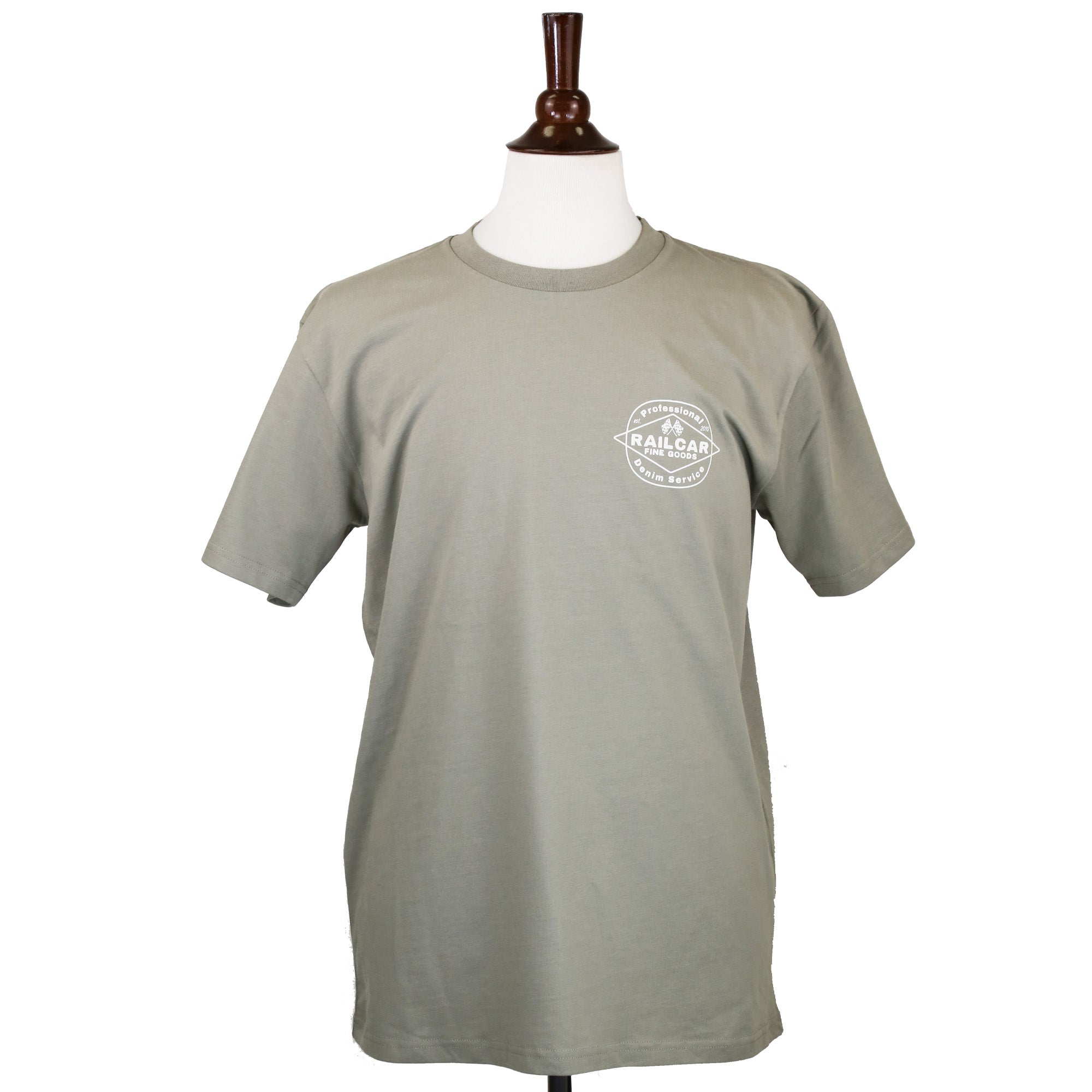 A sage green tee shirt with 'Professional Denim Service' and 'Railcar Fine Goods' printed in off white on the front.