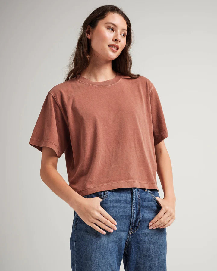 A woman wearing a relaxed fit, short-sleeved, russet-colored crop Richer Poorer t-shirt and blue jeans.