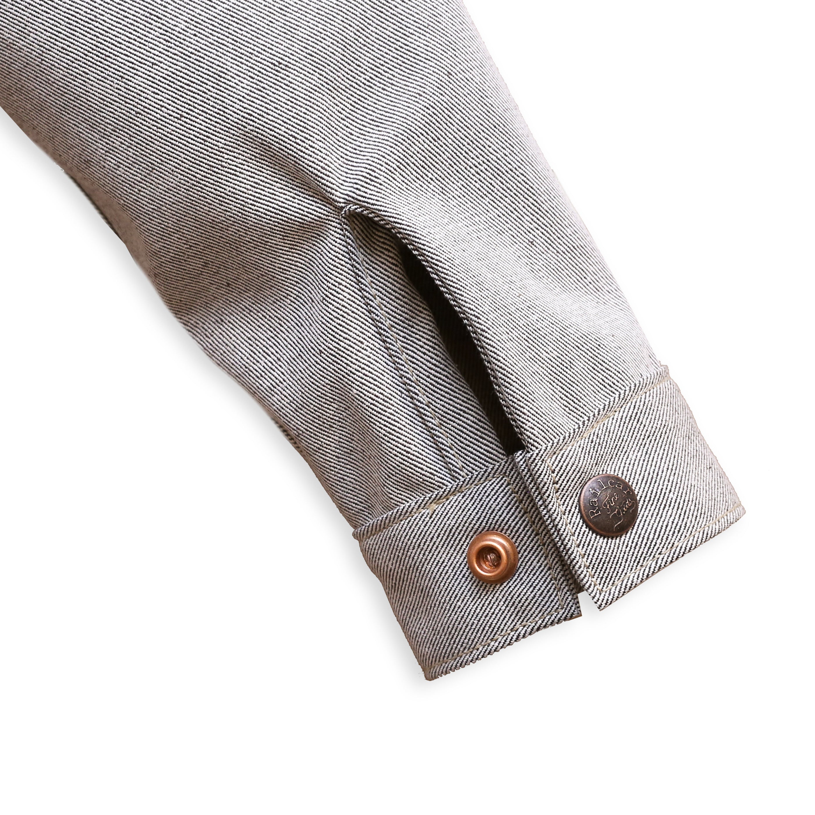 Cuff Detail of a gray Chore Coat with oatmeal denim fabric featuring branded snap buttons.