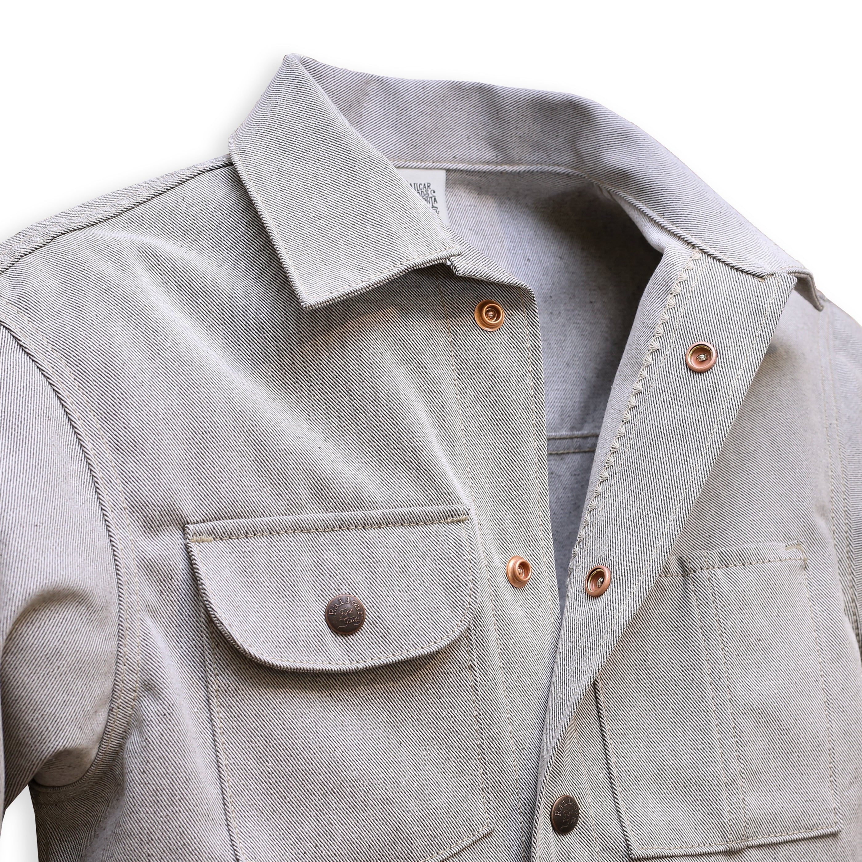 Collar Detail of gray Chore Coat with oatmeal denim fabric, featuring multiple pockets and branded snap buttons.