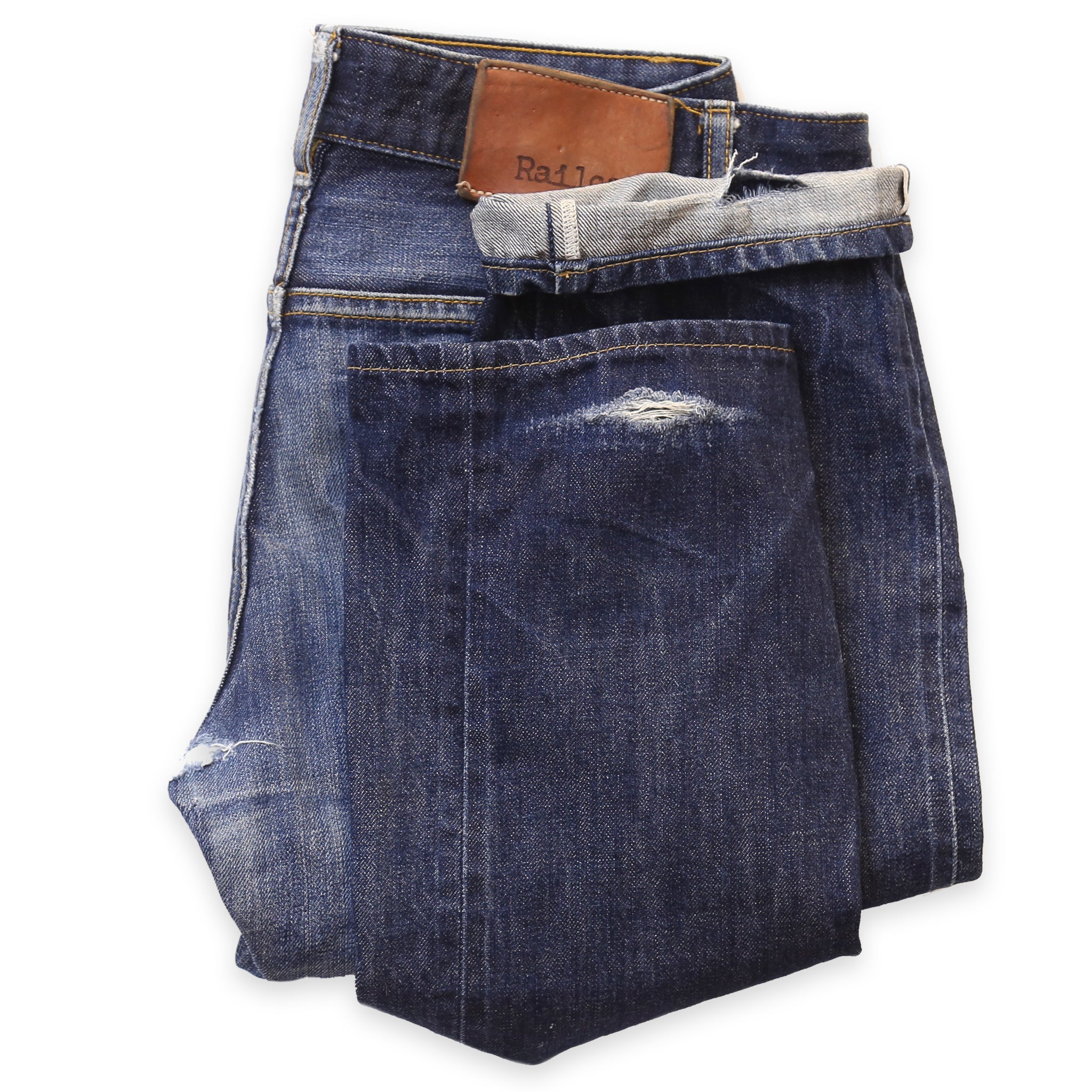 A pair of blue denim jeans with a visible tear at the cuff area, lying flat against a white background.