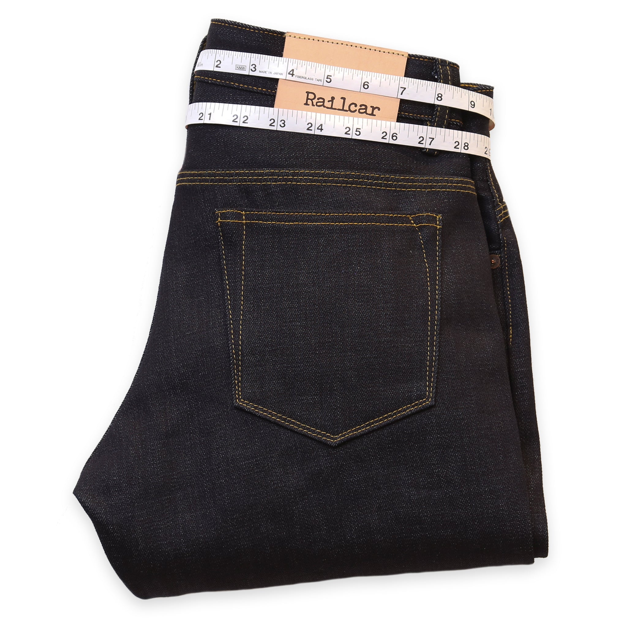 A pair of dark wash denim jeans with a measuring tape laid flat across the waistband, displaying the brand name 'Railcar'.