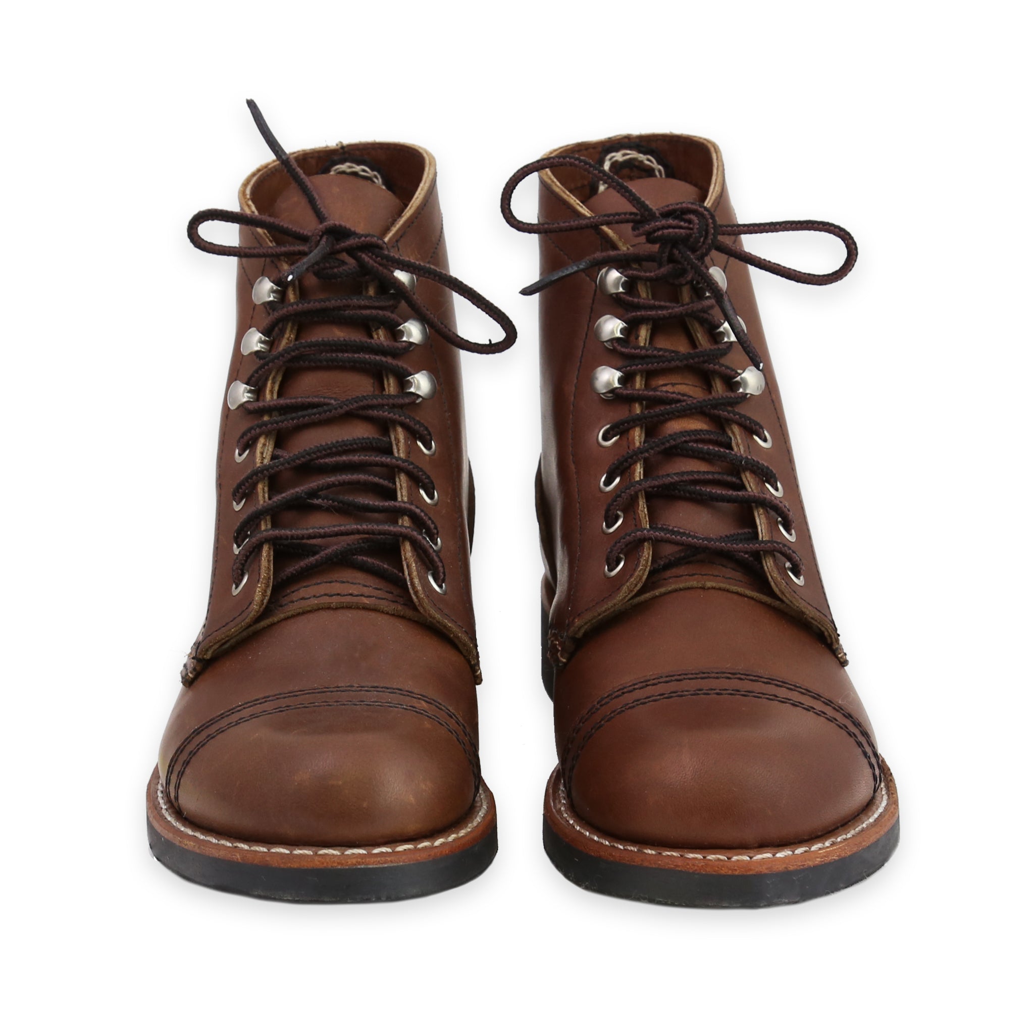 Front of A pair of women's brown leather boots with lace-up closure and a Vibram sole pattern.