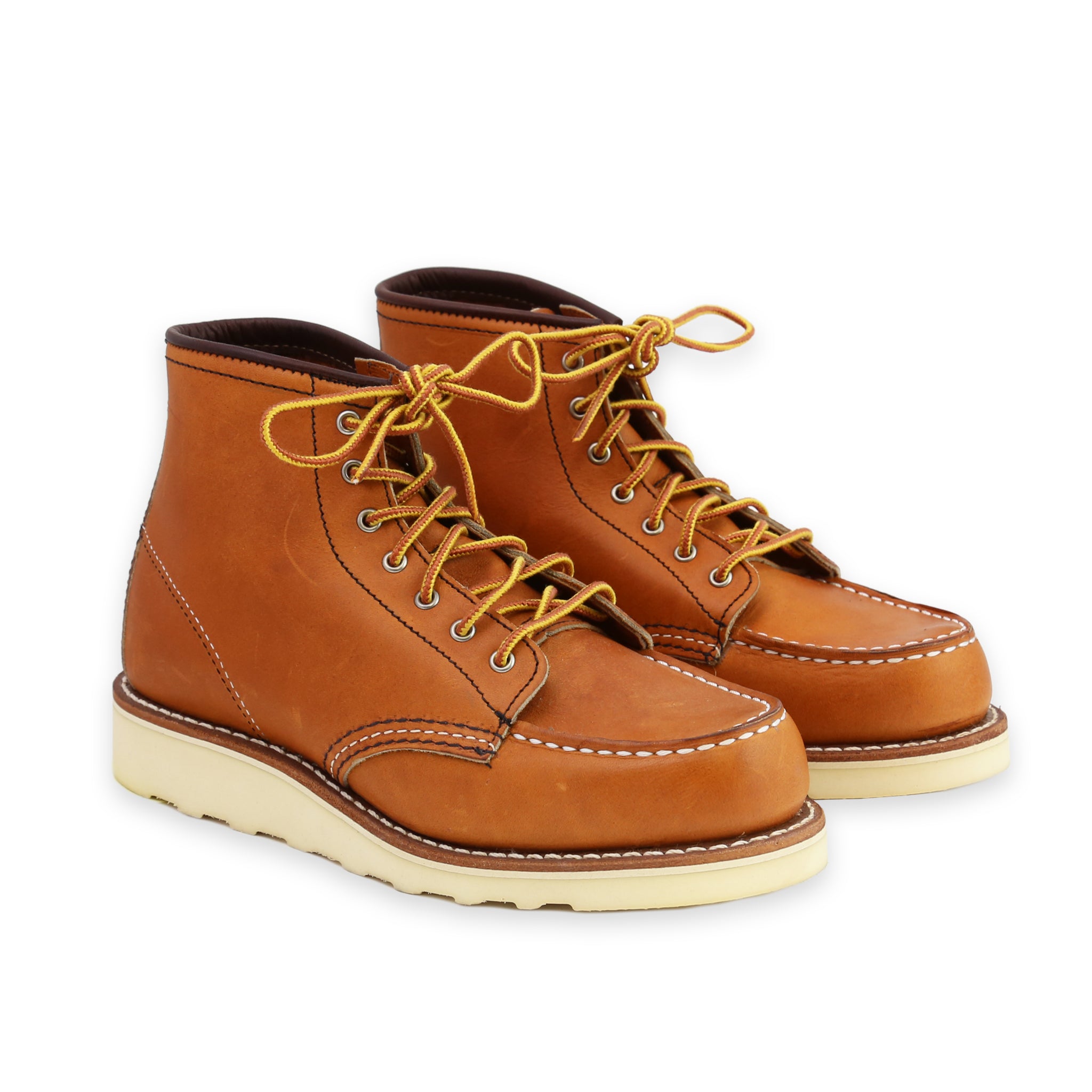 Front Angle of A pair of women's Red Wing Classic Moc Toe Oro Legacy boots with brown leather uppers and a white outsole, featuring lace-up closure.