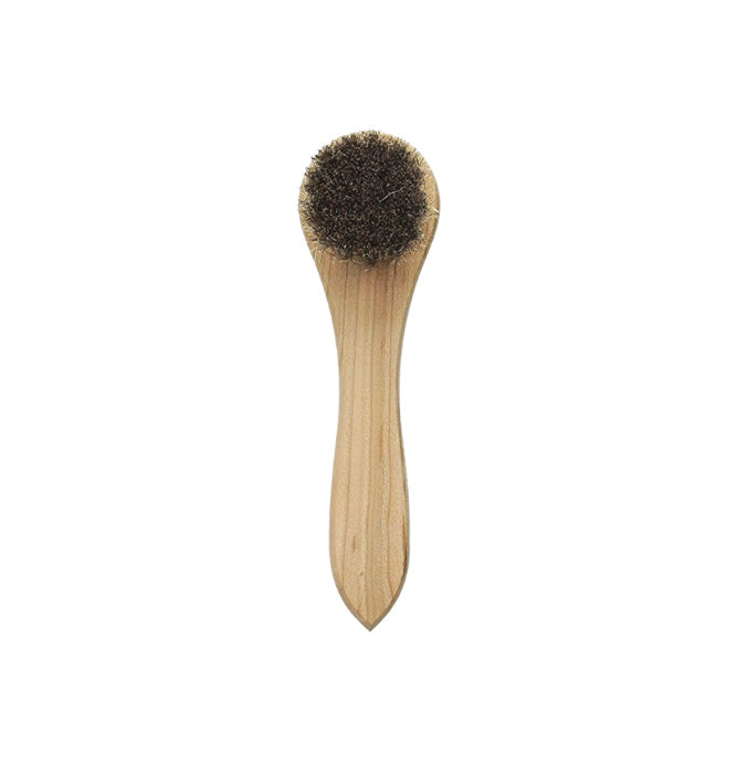 A wooden mini boot brush with bristles