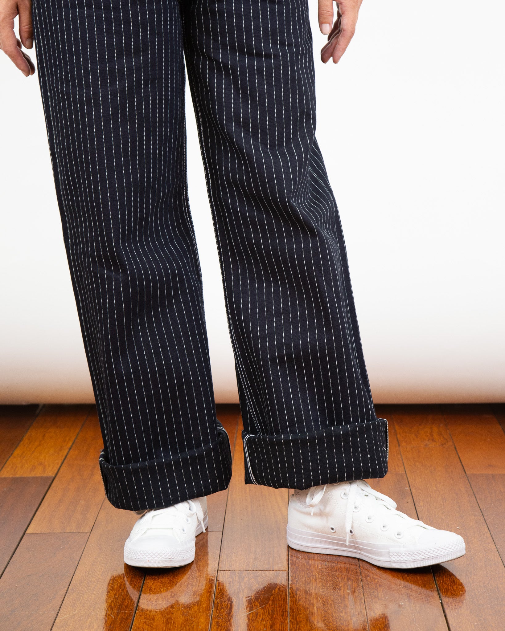 Model wearing Shadow Wabash Emily fit and white sneakers on a wooden floor.