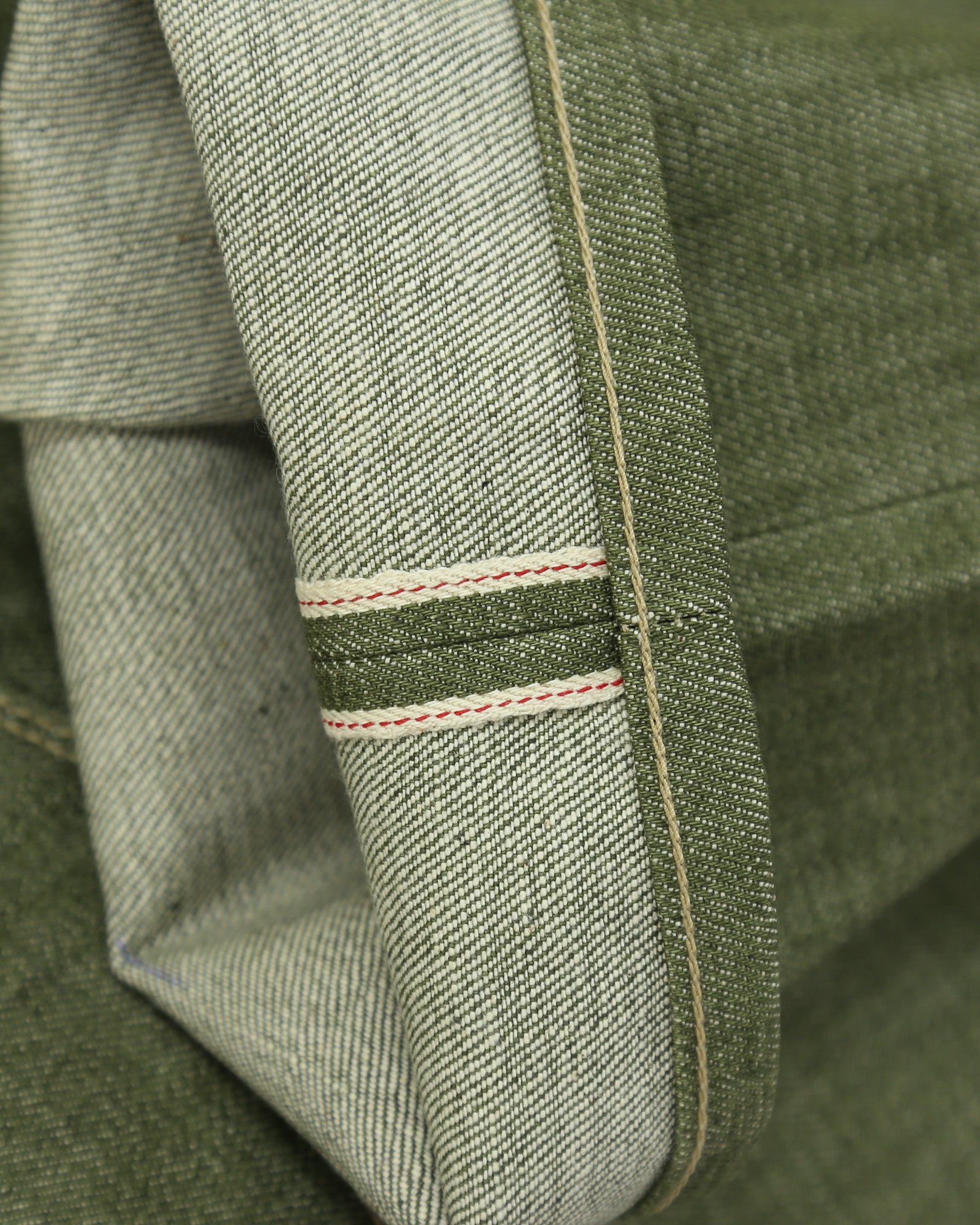 Close-up of x079 Pistachio jeans with selvedge detail.